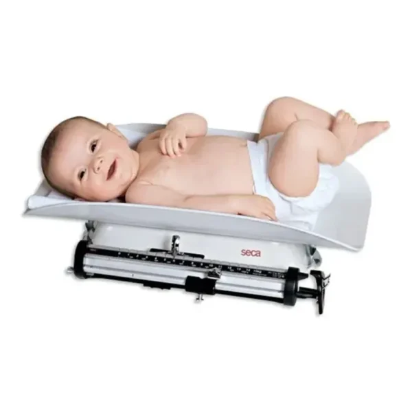 Vista lateral de pesabebés Seca 725 – balanza médica infantil mecánica con artesa ergonómica y ajuste a cero. Con bebe